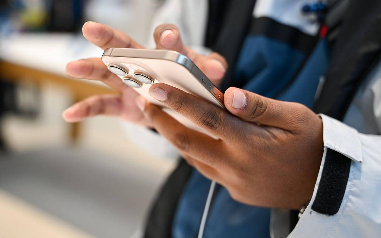 Ein Mann hält ein iPhone 16 in den Händen