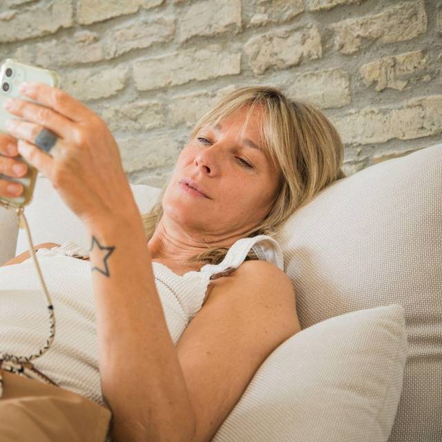 Frau mit Smartphone im Wohnzimmer